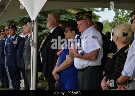 Pensionati New York Air National Guard 106ª Ala di salvataggio Chief Master Sgt. Mike McManus, pararescueman NCOIC, dà ripiegata di bandiera americana per il VFW 1505 Comandante, il sig. Mike Billinger, Keeseville, N.Y., 13 giugno 2018. Il 13 giugno 1978, un HH-3E Jolly gigante verde elicottero dall'102º Aerospace Rescue and Recovery Gruppo ora la 106ª Rescue ala in Westhampton Beach N.Y., stava tornando alla base dopo la formazione a Plattsburgh Air Force Base, N.Y. Dopo aver incontrato condizioni atmosferiche avverse, i sette membri ruotato indietro a Plattsburgh, ma con bassa visibilità, la HH-3E colpire la montagna Trembleau jus Foto Stock