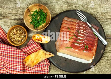 Tagliate a fettine sottili il tedesco il prosciutto della Foresta Nera con fette di pane ciabatta. Tagliate a fette e prosciutto affumicato con schwarzwald prosciutto o prosciutto. Cibo tradizionale tedesco Foto Stock