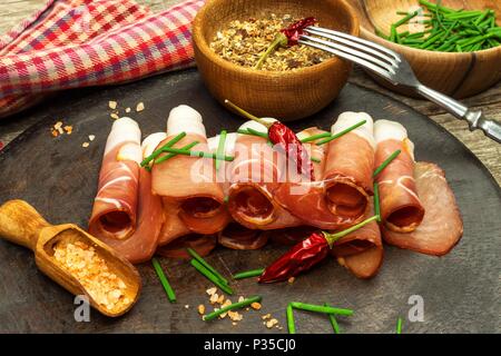 Tagliate a fettine sottili il tedesco il prosciutto della Foresta Nera con fette di pane ciabatta. Tagliate a fette e prosciutto affumicato con schwarzwald prosciutto o prosciutto. Cibo tradizionale tedesco Foto Stock