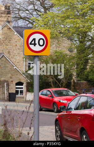 Urban 40 miglia per ora segnale di limite di velocità nel Regno Unito con defocussed traffico in background Foto Stock