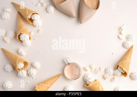 Primavera Estate gara femminile dello sfondo. Vista da sopra con peonia, scarpe, gelato coni di cialda e merengue in beige. Vista da sopra con lo spazio di copia Foto Stock