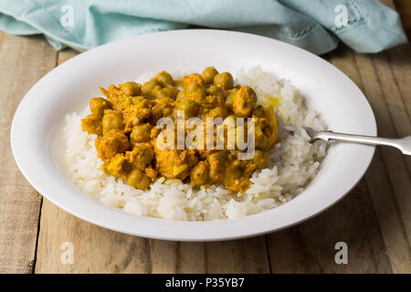 Il curry di ceci con riso nella piastra stretta su tavola in legno rustico Foto Stock