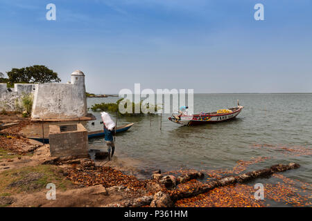 Cacheu, Repubblica di Guinea Bissau - 1 Febbraio 2018: i pescatori preparano le loro canoe nel porto della città di Cacheu in Guinea Bissau. Foto Stock