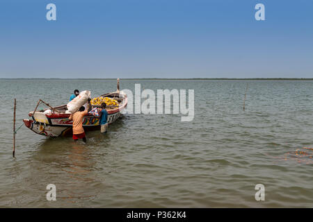 Cacheu, Repubblica di Guinea Bissau - 1 Febbraio 2018: i pescatori preparano le loro canoe nel porto della città di Cacheu in Guinea Bissau. Foto Stock