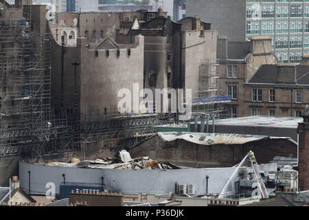 I vigili del fuoco continuano a smorzare verso il basso a seguito dell'incendio presso la Glasgow School of Art (GSA), a sinistra, e l'O2 ABC Glasgow, a destra in Glasgow. Foto Stock