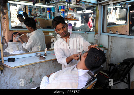 Mumbai, India, uno degli uomini del salon nella baraccopoli di Dharavi Foto Stock