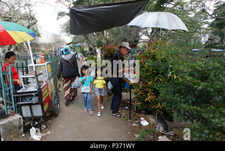 Bogor, Indonesia. 17 Giugno, 2018. L'atmosfera al cimitero pubblico (TPU) Dreded Bogor, West Java, Indonesia. Il 17 giugno 2018. Vacanza di Eid Al-Fitr 1439 Hijriah, residenti fanno pellegrinaggio al cimitero per pregare per la famiglia e i parenti che si riposano in pace. Credito: Adriana Adinandra/Pacific Press/Alamy Live News Foto Stock