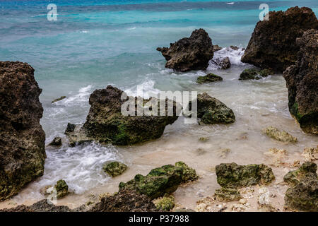 Rocce sulla spiaggia, onde e acque turchesi. Il Boracay Island, Filippine Foto Stock