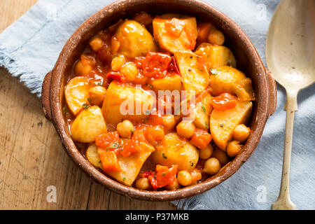 Patatas bianche. Patate arrosto con ceci in salsa di pomodoro. Foto Stock