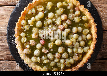 Dolci fatti in casa crostata con un ripieno di acini di uva spina vicino sul tavolo. parte superiore orizzontale vista da sopra Foto Stock