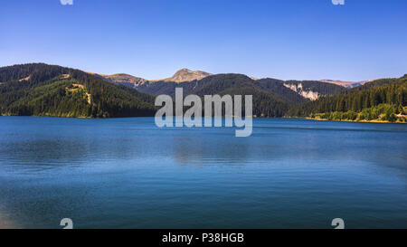 Vista lago Bolboci dal leggermente umido con le montagne dei Carpazi in background, Sinaia, Romania. Foto Stock