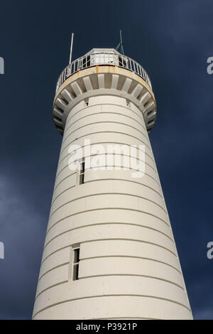 Donaghadee County Down, Irlanda del Nord. 17 giugno 2018. Tempo nel Regno Unito - dopo una giornata di pioggia, ci sono stati alcuni brevi periodi di sole a tarda ora. Luce del sole sulla pietra miliare bianca del faro di Donaghadee con cieli scuri sopra la sua testa. Crediti: David Hunter/Alamy Live News. Foto Stock