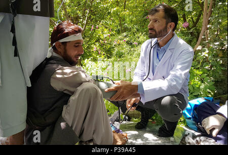 A Kabul, Afghanistan. Il 18 giugno, 2018. Uno dei membri della marcia per la pace che camminava quasi 700 chilometri dalla Southern Helmand a Kabul, Afghanistan viene trattata da un medico dopo l'arrivo in una grande moschea al centro della città di Kabul. Stanco della guerra, decine di sostenitori di pace fatta il 37 viaggio di un giorno a Kabul per chiedere la fine della continua e interminabile guerra. Foto: Mohammad Jawad/dpa Credito: dpa picture alliance/Alamy Live News Foto Stock