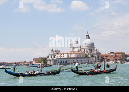 Gondole con turisti asiatici di fronte a Punta della Dogana e la Basilica di Santa Maria della Salute, Grand Canal, Venezia, Veneto, Italia. Biat occupato Foto Stock