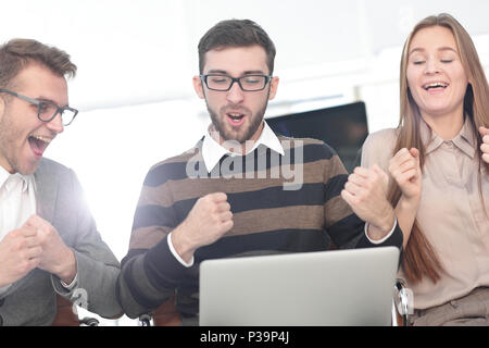 Tre dipendenti eccitati ricevendo buone notizie insieme sulla linea Foto Stock