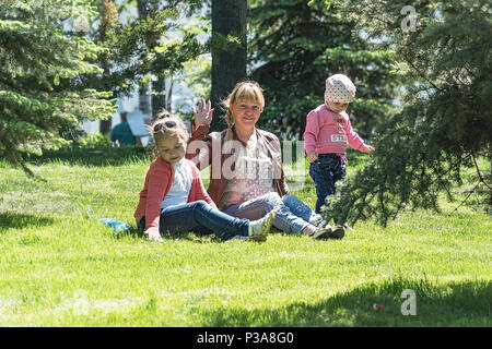 La Russia, Samara, 27 Maggio 2018: la mamma con due bambini nel parco sul prato Foto Stock