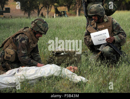 HUNTER LIGGETT, California (22 aprile 2009) Hopspital Corpsman 2a classe Damian giovani, assegnato alla Naval Mobile Battaglione di costruzione (NMCB) 3, e la sua interprete, Costruzione elettricista di seconda classe Alcanzaren Frantel, trattare un civile con una simulazione di ferite durante il funzionamento del cuscinetto 2009 duello. Cuscinetto Duel è un campo annuale di esercizio per testare il battaglione della capacità di distribuzione in un ambiente di emergenza. Foto Stock