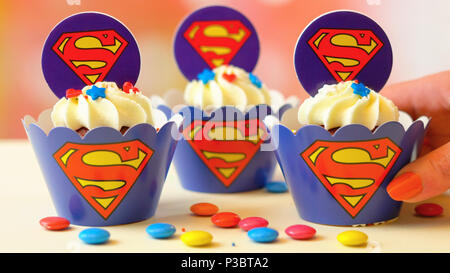 Adelaide, Sud Adelaide - Giugno 15, 2018: la decorazione di festa di compleanno di bambini a tema superman tortini, chiudere in su contro un colorato sfondo pastello Foto Stock