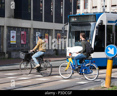 Le biciclette e i tram, le forme più popolari di trasporto in Amsterdam Foto Stock