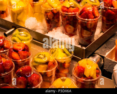 La fragola e kiwi insalate in bicchieri di plastica presso il mercato centrale di Valencia, Spagna Foto Stock