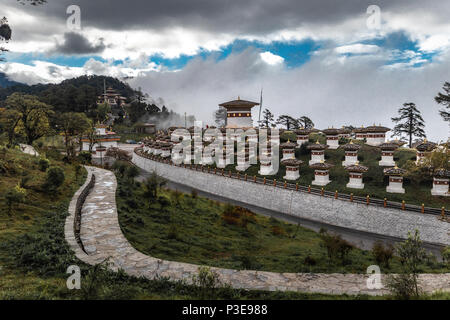 108 memorial chortens di Dochula seduto nella sua gloria sotto con le nuvole pesanti dando modo al cielo blu Foto Stock