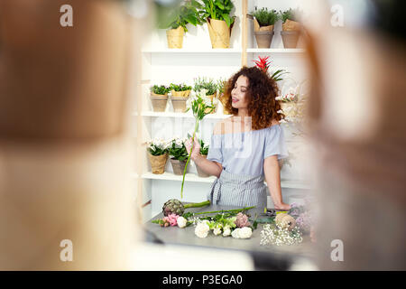 Gioiosa affascinante donna in piedi al tavolo Foto Stock