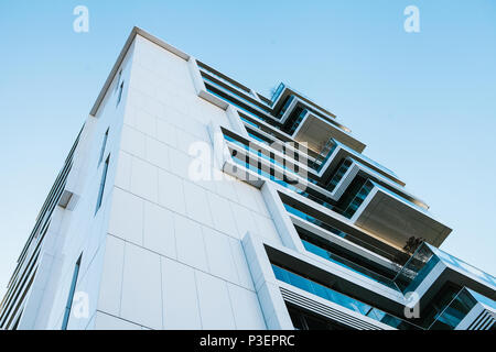 L'angolo dell'edificio con molte finestre contro il cielo blu Foto Stock