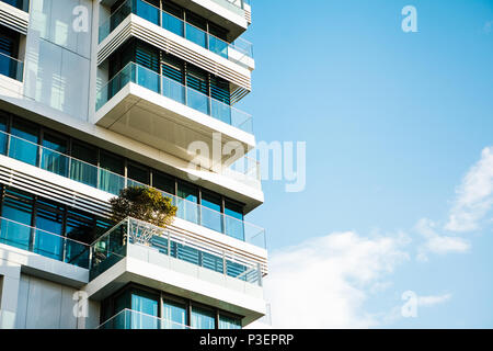 L'angolo dell'edificio con molte finestre contro il cielo blu Foto Stock