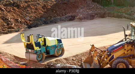 Costruzione schiacciasassi e bulldozer su una costruzione casa il consolidamento delle basi - casa moderna costruzione Foto Stock