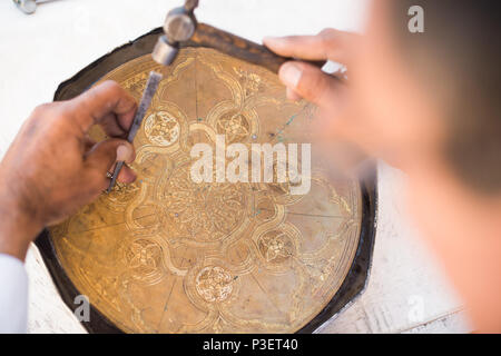 Artigiano di modelli di incisione sul vassoio. maestri dell Asia centrale. Manuale di coniazione di rame Foto Stock