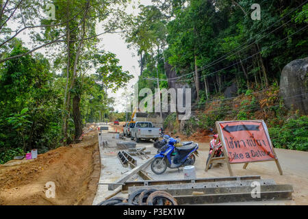 Lavoratori edili provenienti dal Myanmar sono la costruzione di nuove strade attraverso la giungla che copre le montagne dell'isola thailandese di Koh Phangan, Thailandia Foto Stock