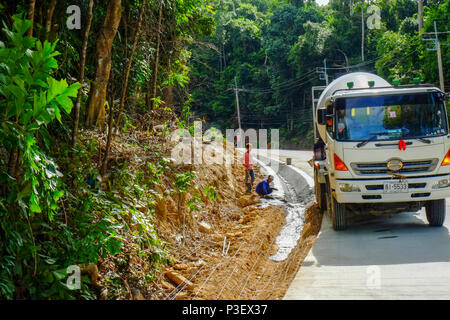 Lavoratori edili provenienti dal Myanmar sono la costruzione di nuove strade attraverso la giungla che copre le montagne dell'isola thailandese di Koh Phangan, Thailandia Foto Stock