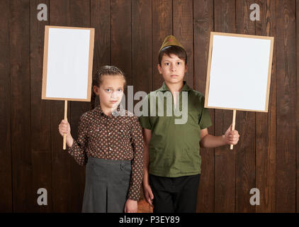 I bambini sono vestiti in retrò uniformi militari. Si stanno tenendo i poster in bianco per i veterani dei ritratti. Foto Stock