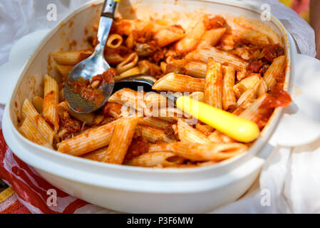 Mangiare maccheroni dal contenitore in plastica ciotola in natura camping. A pranzo da pasti precotti immagazzinati in trasportabili in contenitore di plastica e ea Foto Stock