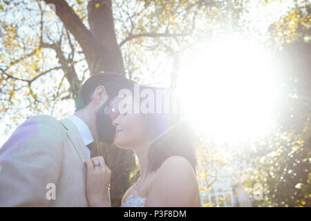 Sorridente sposa e lo sposo abbracciando in giardino Foto Stock