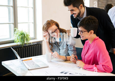 Un gruppo di giovani architetti che lavorano su laptop Foto Stock