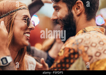 Close up della giovane coppia danzante presso il festival di musica. L uomo e la donna in stile hippie avendo divertimento all'aperto. Foto Stock