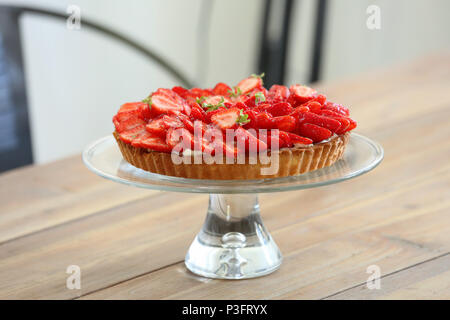 Crostata con fragole fresche su uno sfondo di legno Foto Stock