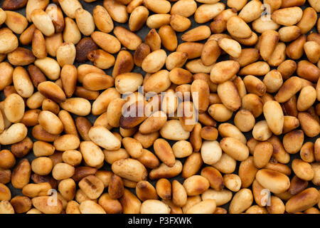 Pinoli da un supermercato che sono state tostato in una padella prima di essere servita come un condimento per i filetti di sgombro cotto in una salsa Harissa. L Foto Stock