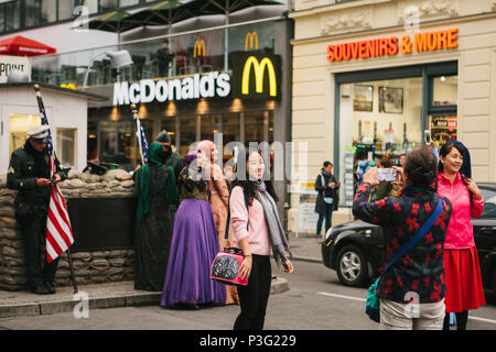 Berlino, 1 ottobre 2017: turisti asiatici sono fotografate accanto a una città famosa attrazione chiamata Chekpoint Charlie Foto Stock