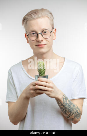 Ritratto di un giovane biondo uomo con cactus Foto Stock