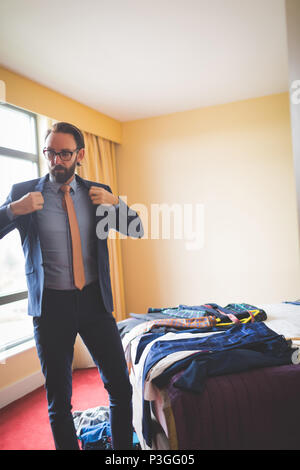 Imprenditore indossa blazer in camera di albergo Foto Stock