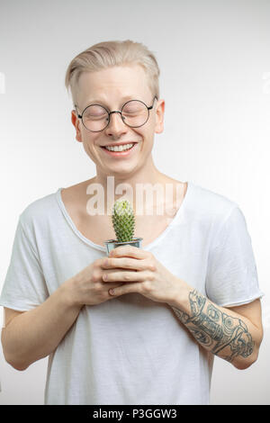 Ritratto di un giovane biondo uomo con cactus Foto Stock