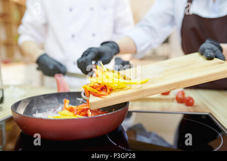 Gli chef cucinare nel ristorante cucina Foto Stock