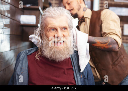 Positivo il piacere pensionato aspettano di nuovo taglio di capelli Foto Stock