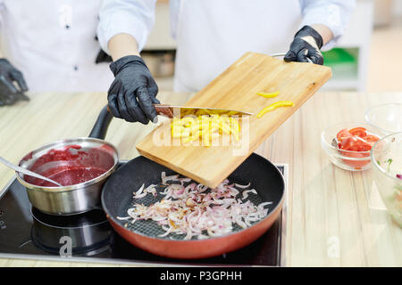 Lo chef cucina verdure Foto Stock