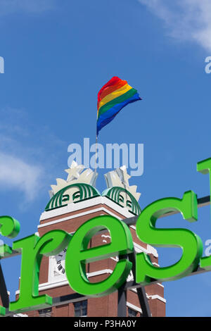 Seattle, Washington: Starbucks segna LGBTQ Pride mese con il sollevamento della bandiera di orgoglio in corrispondenza del loro punto di riferimento headquarters building in sodo. In primo piano è la Amazon AmazonFresh segno dal loro negozio di generi alimentari pick up location alloggiato nello stesso edificio. Credito: Paolo Christian Gordon/Alamy Live News Foto Stock