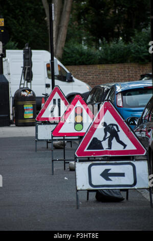 Gli uomini al lavoro, semaforo e la strada si restringe costruzione segni in Stoke Newington, Hackney, Londra Foto Stock