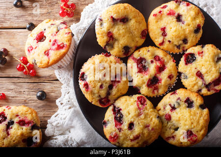 Muffin di bacche con nero e ribes rosso vicino sul tavolo. parte superiore orizzontale vista da sopra Foto Stock