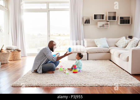 Nero padre e figlio toddler giocando in salotto Foto Stock